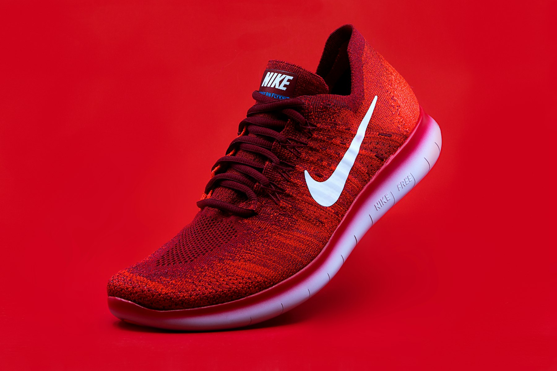 Bright red performance sneaker photographed from above on a pale surface