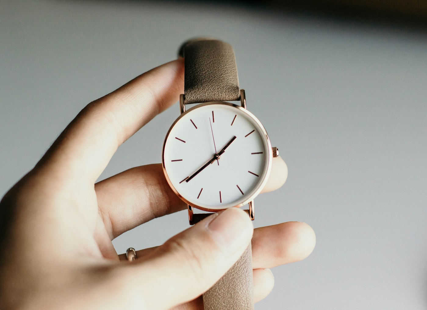 Silver analog watch on a wrist, case and bracelet in close daylight